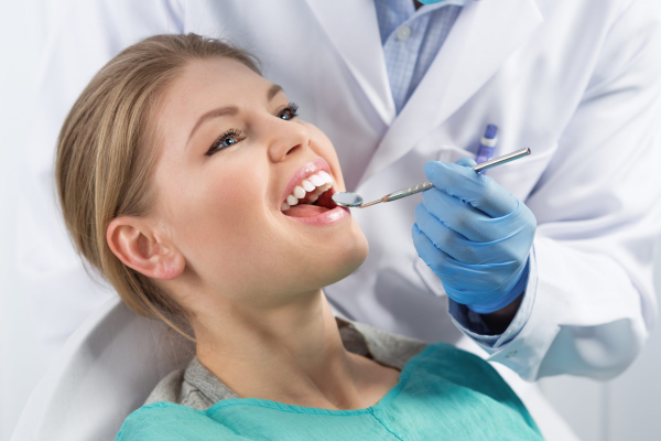 Female dental patient smiling during exam at Southcentre Tower Dental in Calgary SE